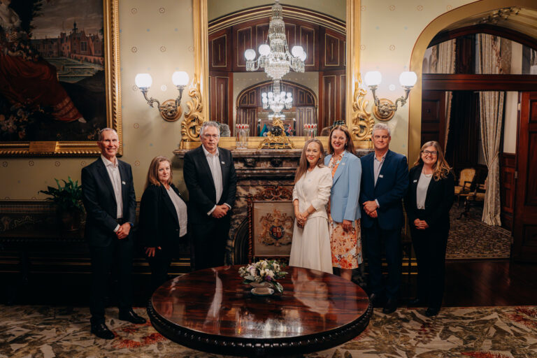 Formal group portrait of event attendees inside the historic Government House Sydney