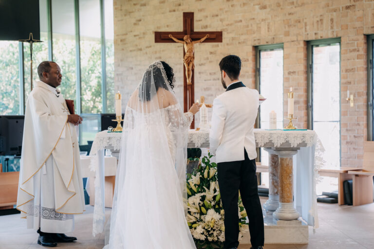 Bride and groom standing at the altar with the priest during their church wedding.