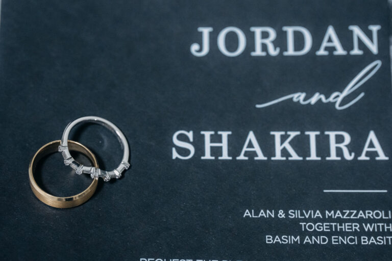 Jordan and Shakira's personalised wedding invitation displayed alongside their wedding rings.