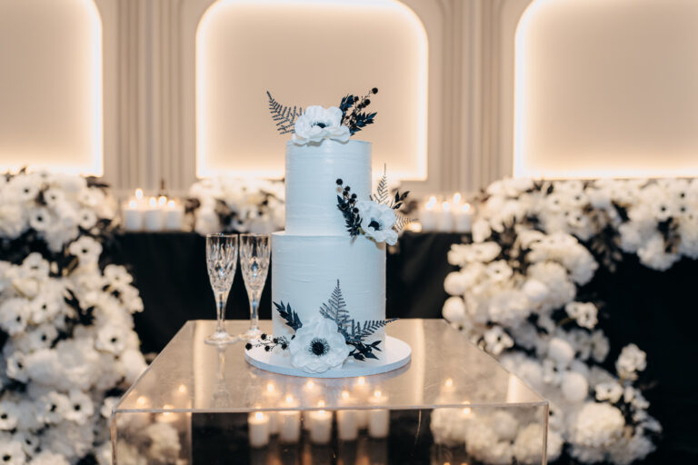 Elegant white wedding cake decorated with flowers at Jordan and Shakira's reception.