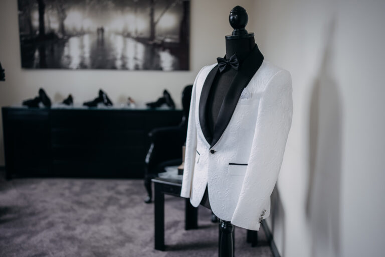 Black and white wedding preparation photograph of the groom's white tuxedo.