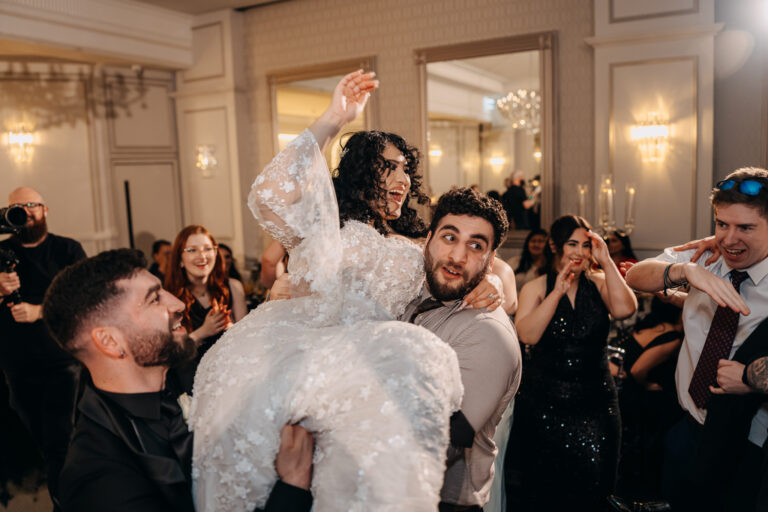 Bride lifted above the crowd during an energetic wedding reception celebration.
